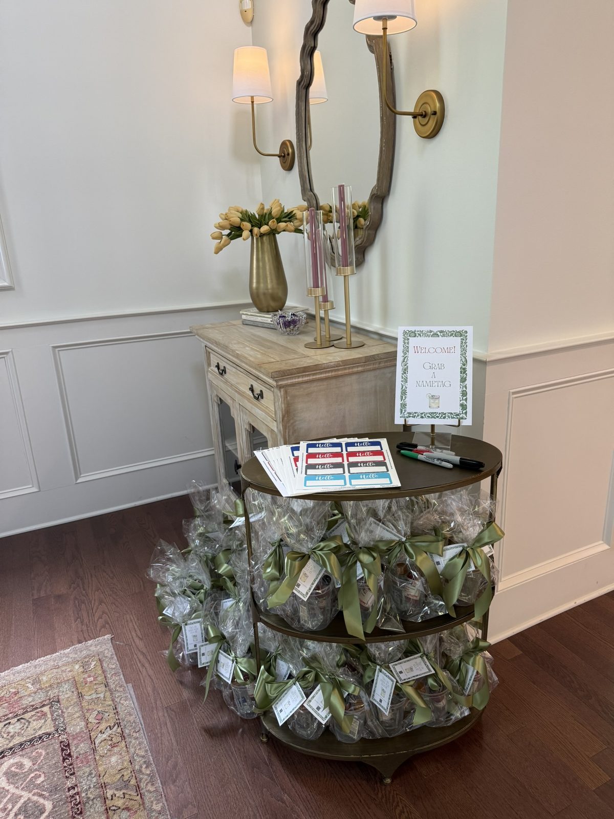 A welcome table with nametags and wrapped take-home gifts tied with ribbon.