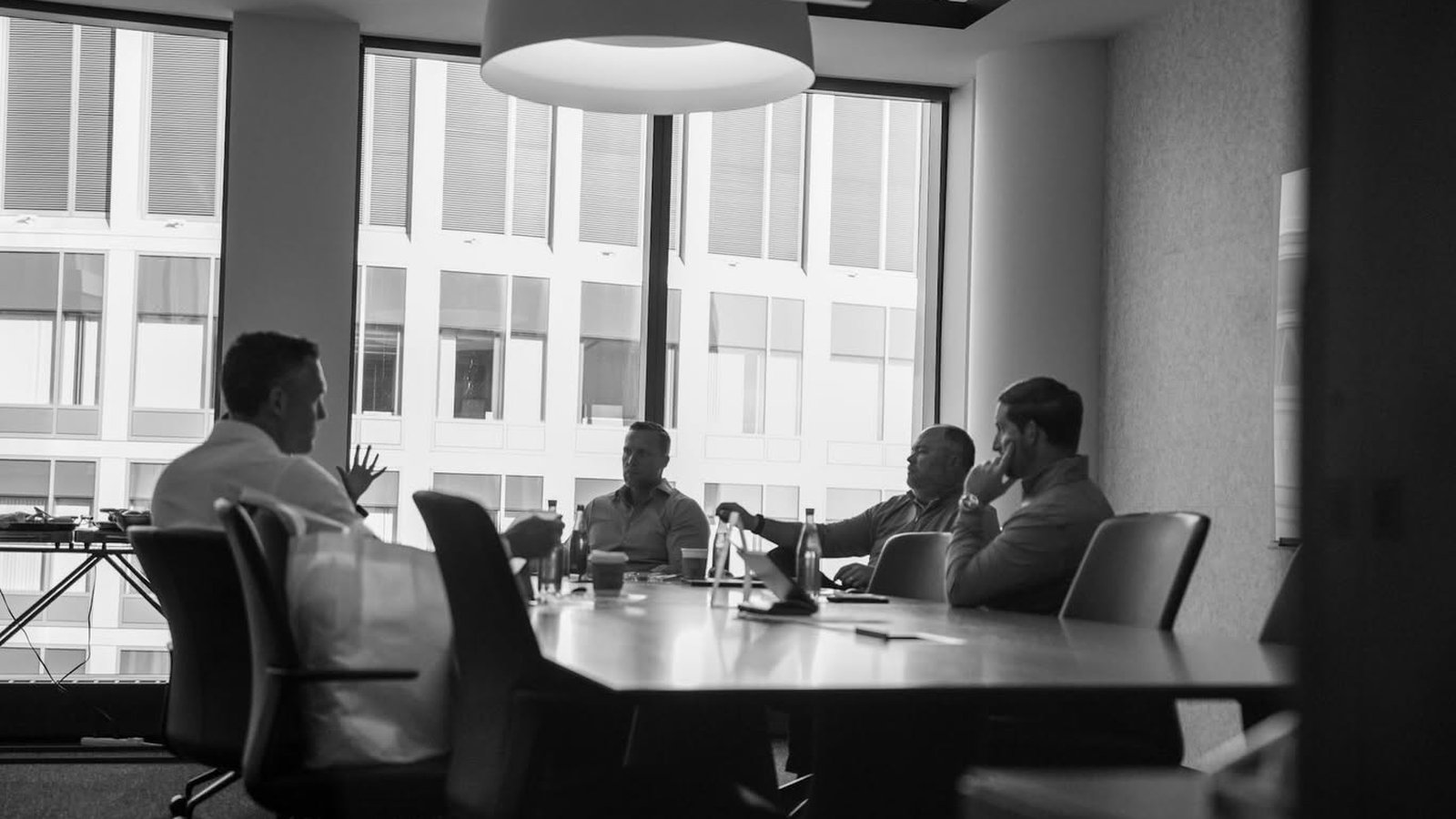 The four Veritas partners in a working meeting around a conference table.